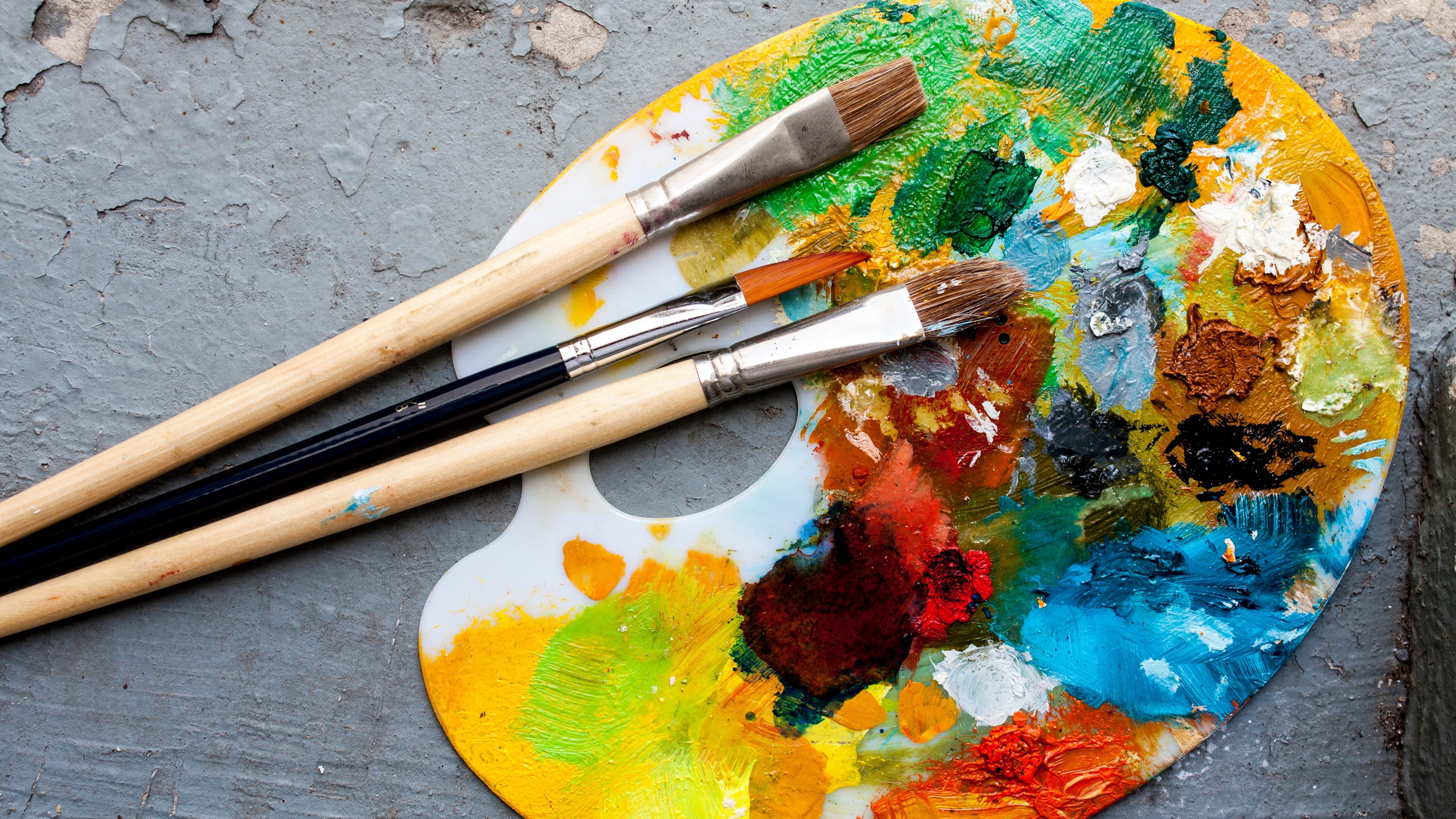 Brushes and colorful abstract oil colors painters pallet, on retro background